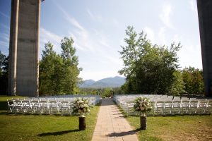 Chairs lined up for a wedding ceremony with the backdrop of the adk mountains on a summer day.